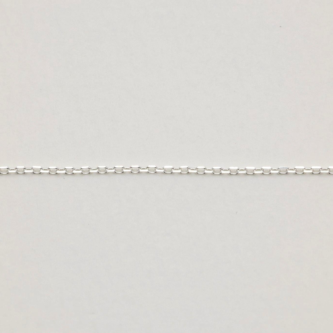 Subtle shine of the chain links capturing light against a soft surface.