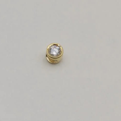 14K gold charm with bezel-set lab-grown diamond on cream background, photographed from front and side angles.
