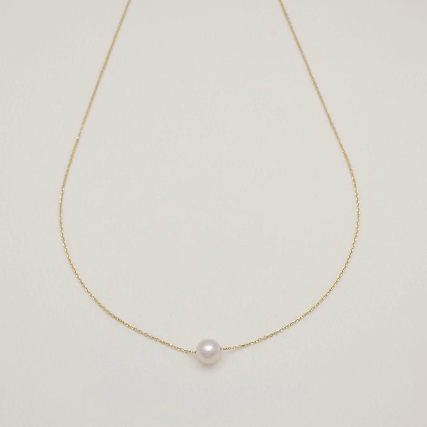 Pearl necklace on a light gray background
