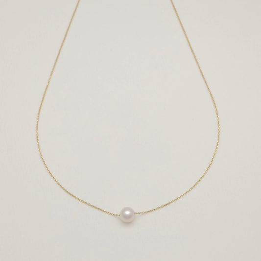 Pearl necklace on a light gray background