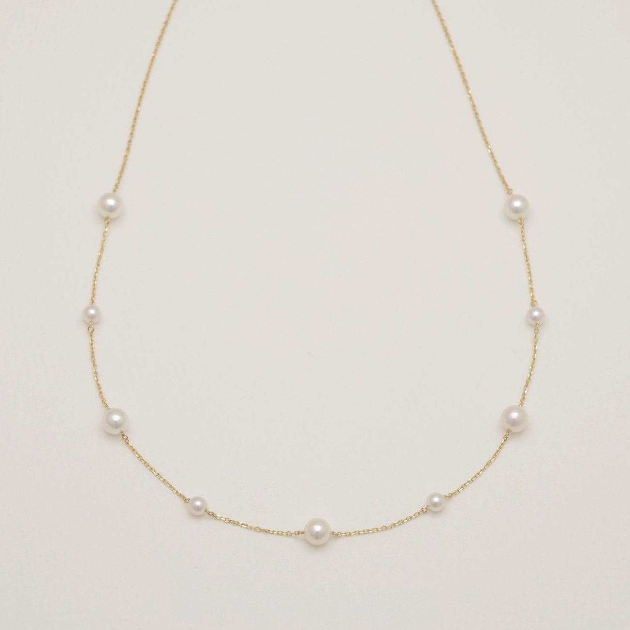 Pearl necklace on a light beige background