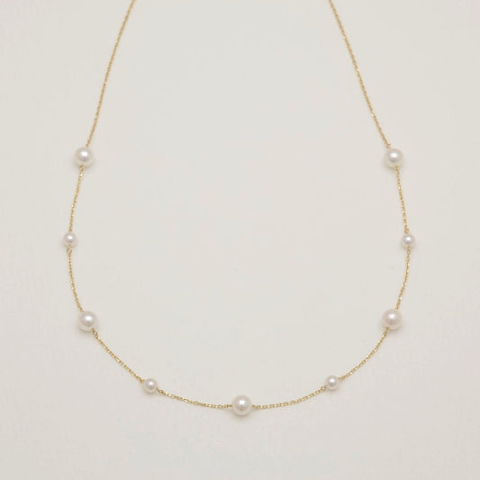 Pearl necklace on a light beige background