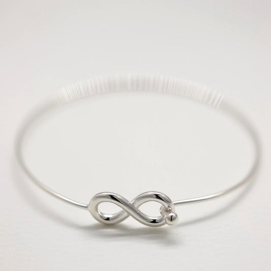Infinity bangle bracelet in polished sterling silver on white background