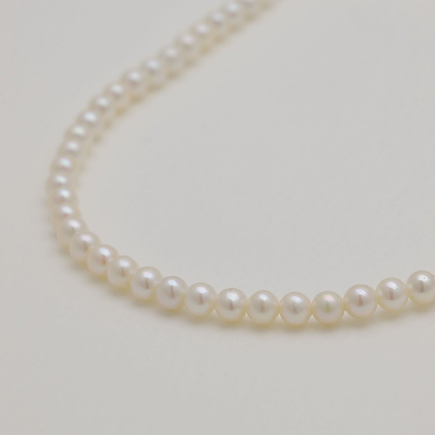 Close-up of lustrous pearls along necklace strand.