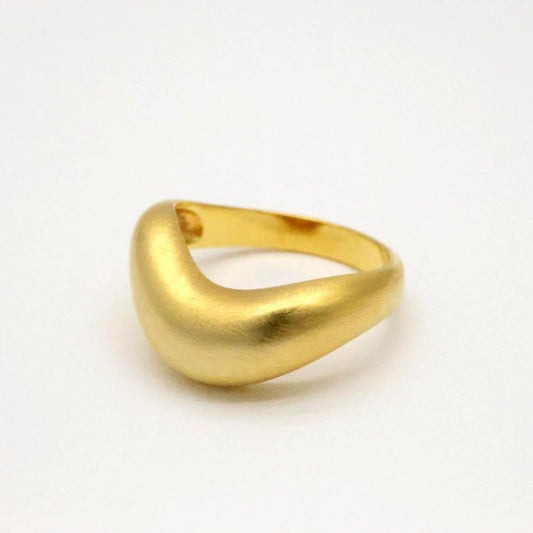 Matte gold vermeil sculptural ring with smooth organic curve, shown from a side angle on white background.