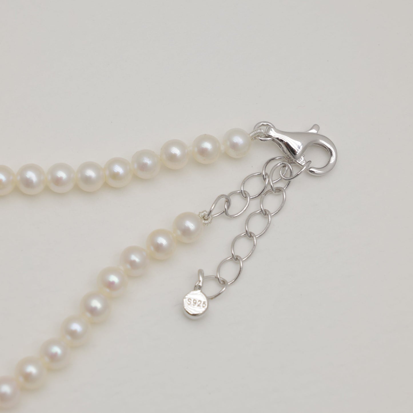 Detail view of lobster clasp and extender chain with 925 tag.