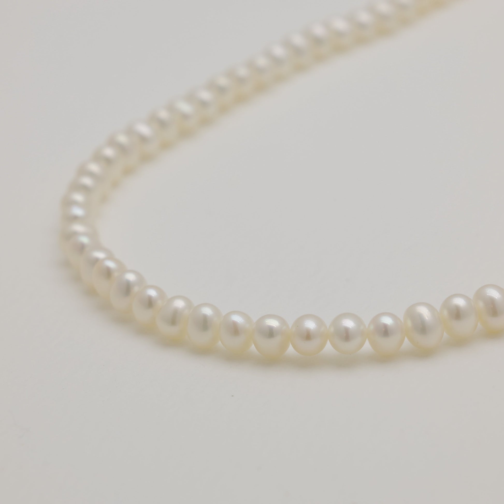 Pearl necklace on a light gray background