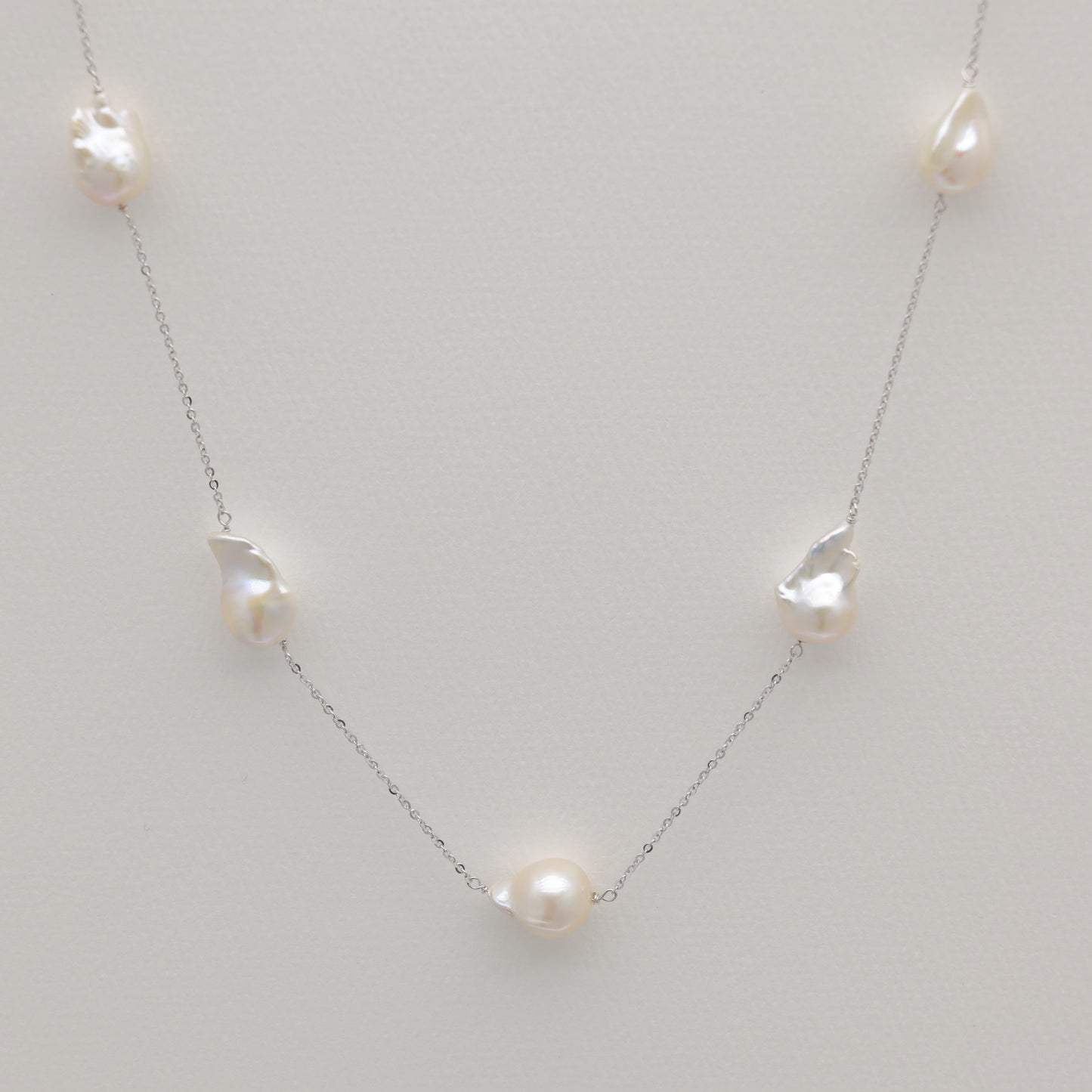 Long baroque pearl necklace in sterling silver featuring irregular freshwater pearls.