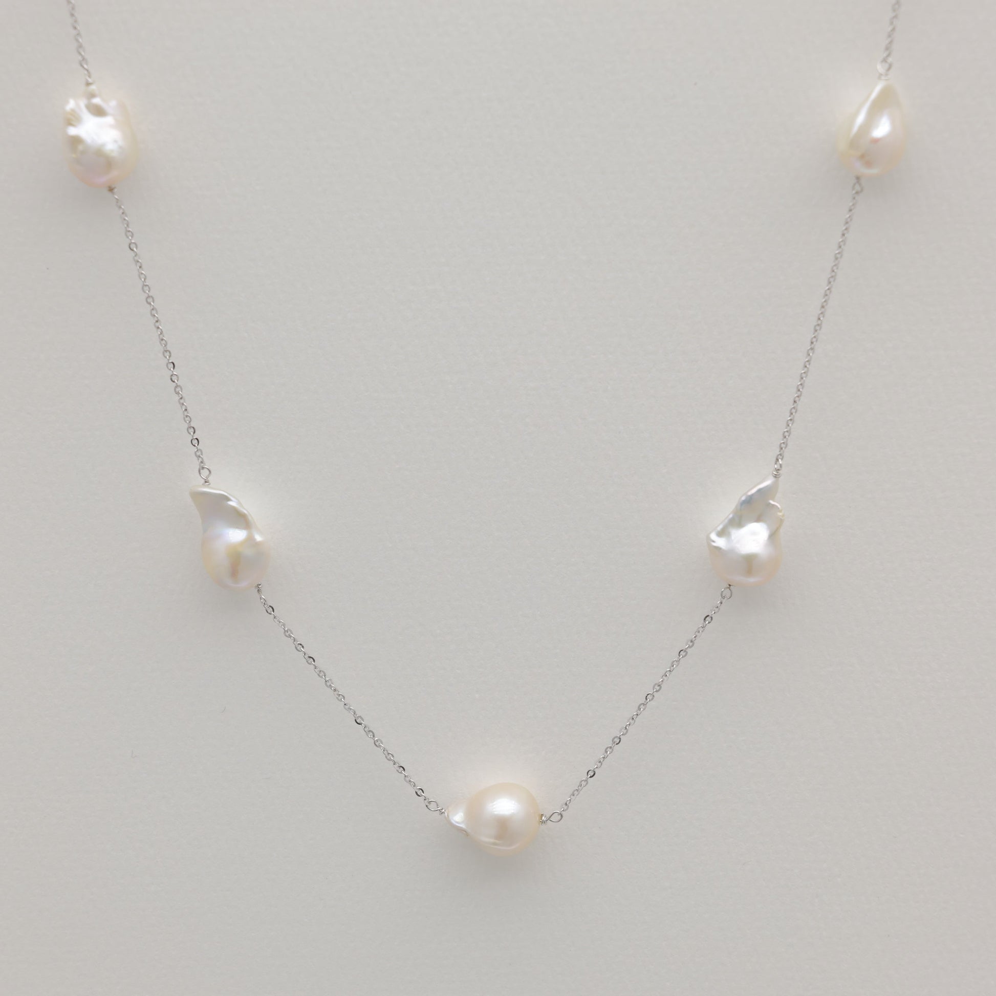 Long baroque pearl necklace in sterling silver featuring irregular freshwater pearls.