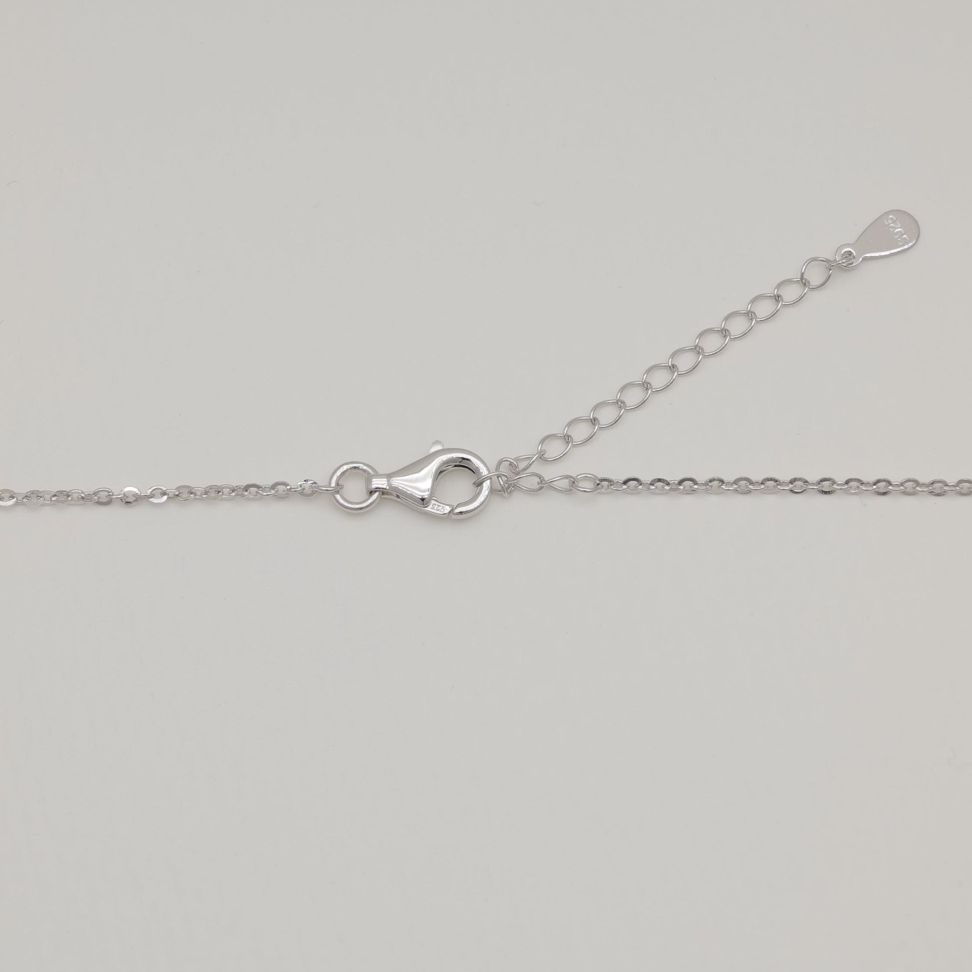 Silver chain necklace on a light gray background