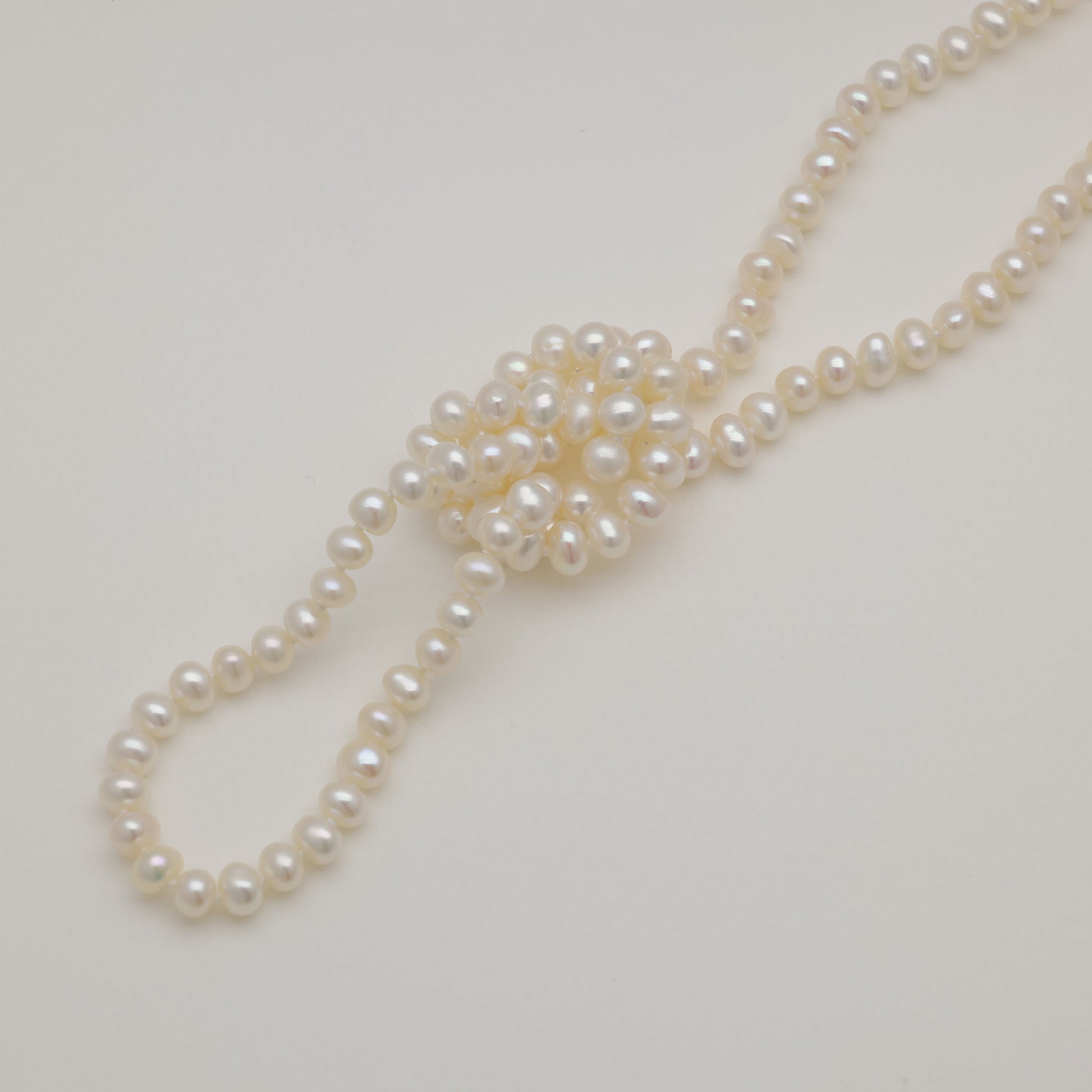 Pearl necklace on a light gray background