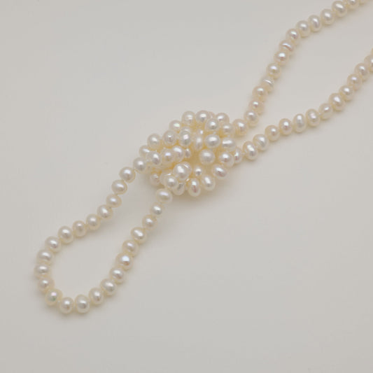 Pearl necklace on a light gray background