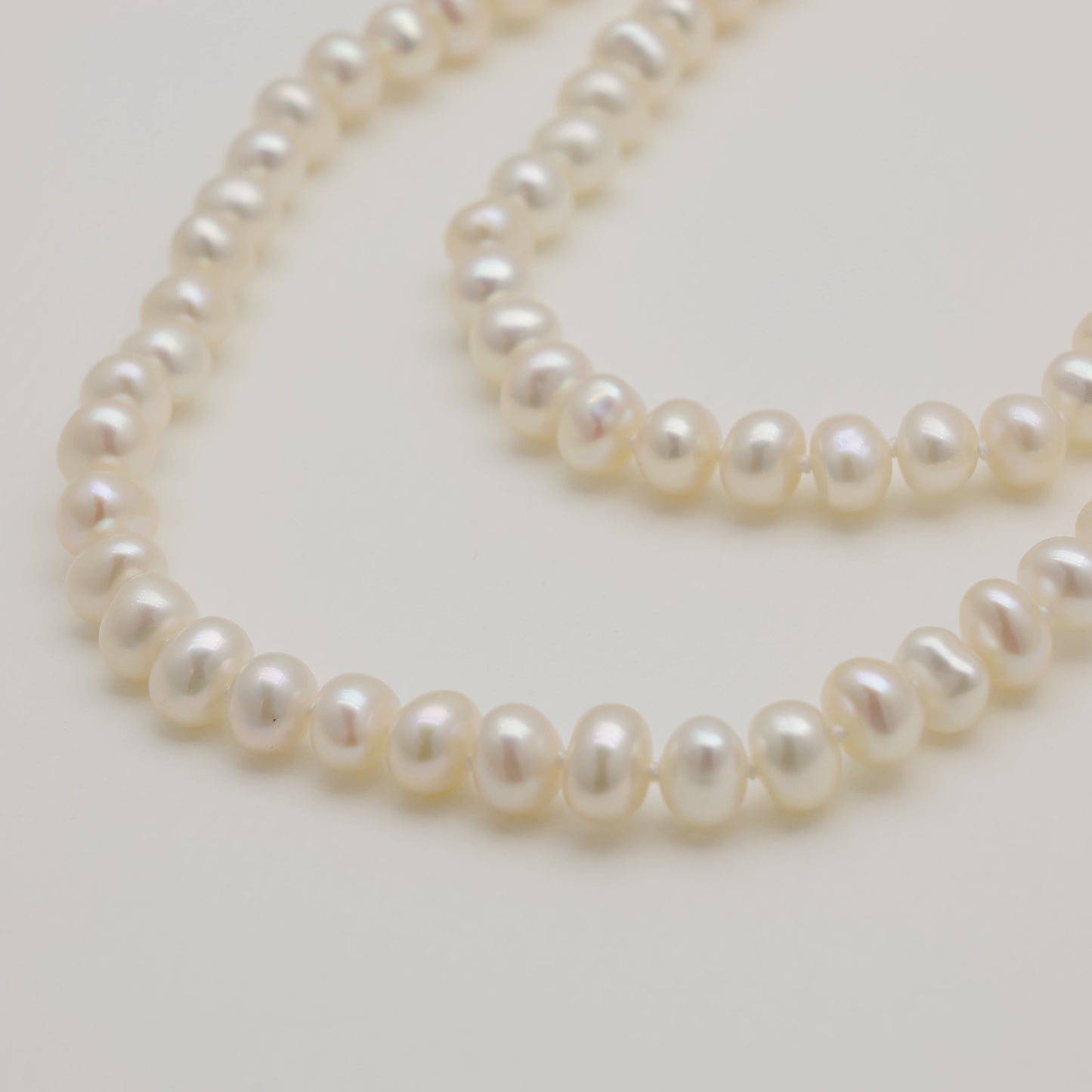 Pearl necklace on a light gray background