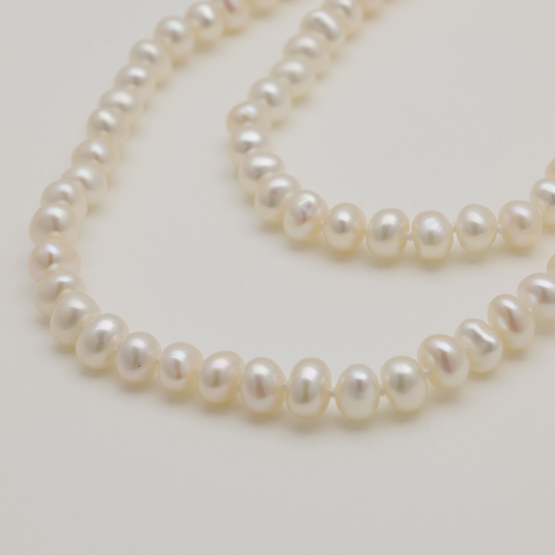 Pearl necklace on a light gray background