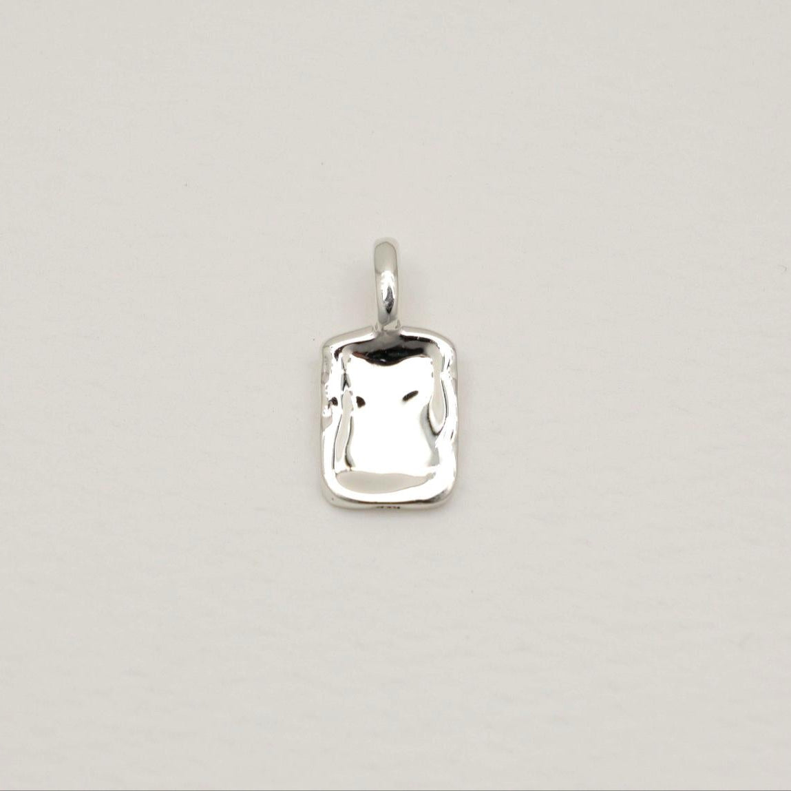 A softly contoured rectangular tag pendant in polished 925 sterling silver with rippled texture, styled on a white background.