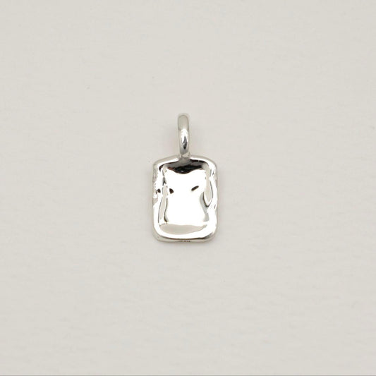 A softly contoured rectangular tag pendant in polished 925 sterling silver with rippled texture, styled on a white background.