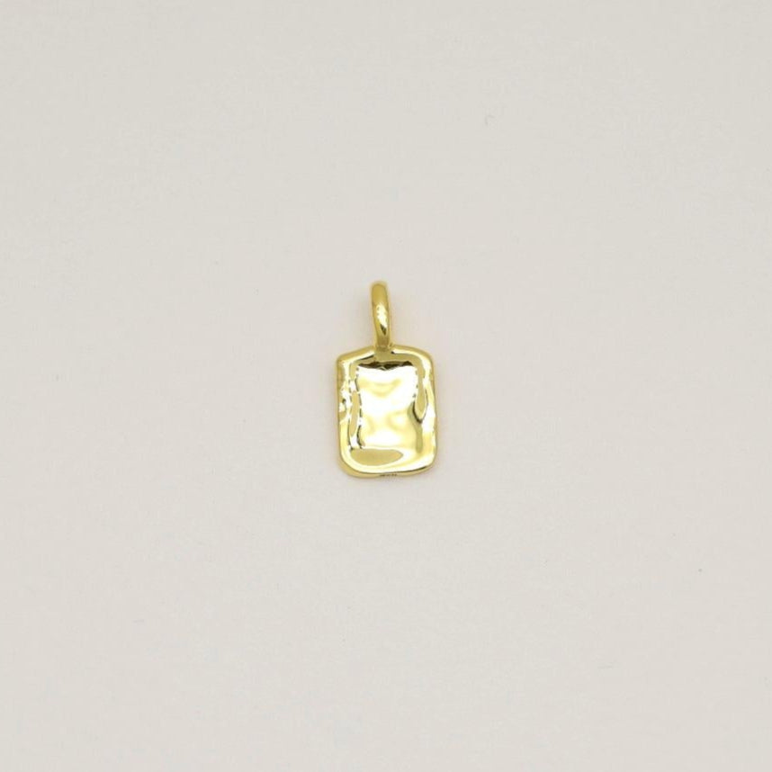 Gold vermeil rectangular tag pendant with soft rippled texture, photographed on a neutral background.