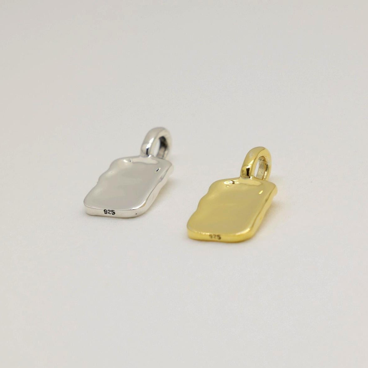 Gold vermeil rectangular tag pendant with soft rippled texture, photographed on a neutral background.