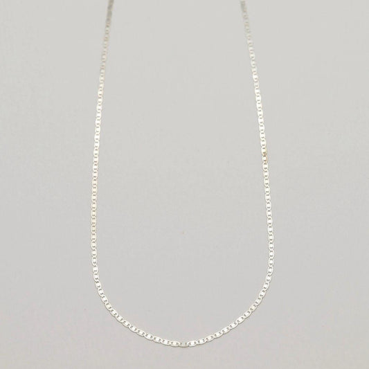 A full-length view of the Aliane Chain Necklace in 925 sterling silver, laid in a soft curve against a neutral backdrop.