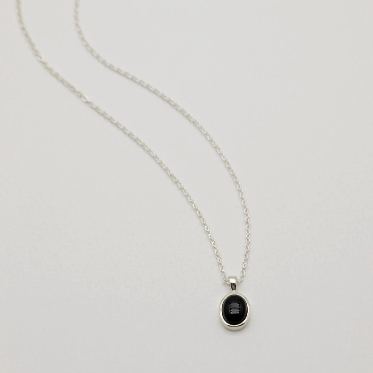 Sterling silver pendant with black onyx stone in a round bezel setting. Clean, minimal, and elegant.