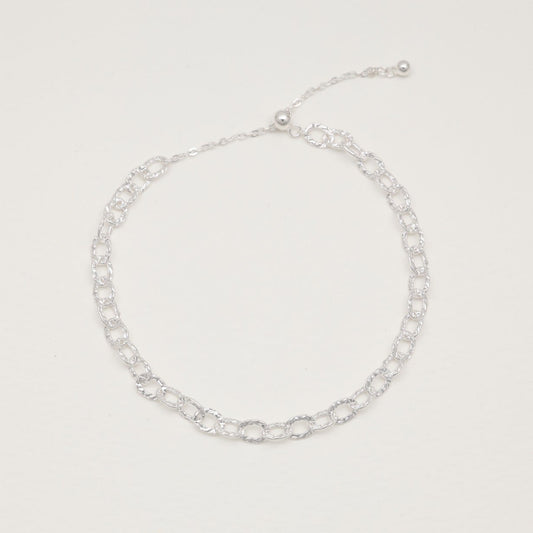 Sterling silver loop bracelet with hammered links on white background"