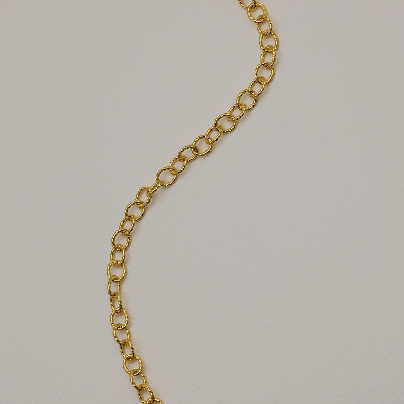 Gold chain on a light gray background