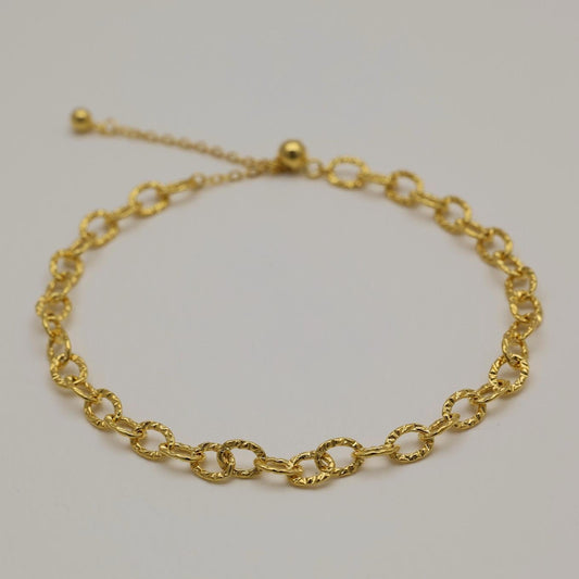 Gold vermeil bracelet featuring twisted loop chain links with polished finish, shown on neutral background.