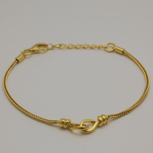 Gold vermeil bracelet with braided chain and loop detail, laid flat and in a circular shape.