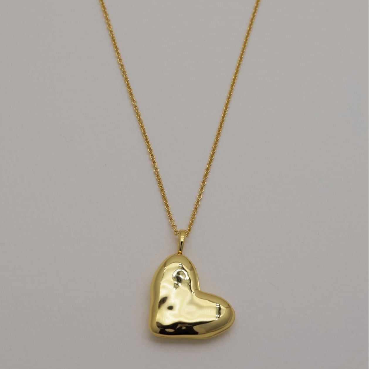 Gold vermeil heart locket necklace with polished finish, photographed open and closed on a plain background.