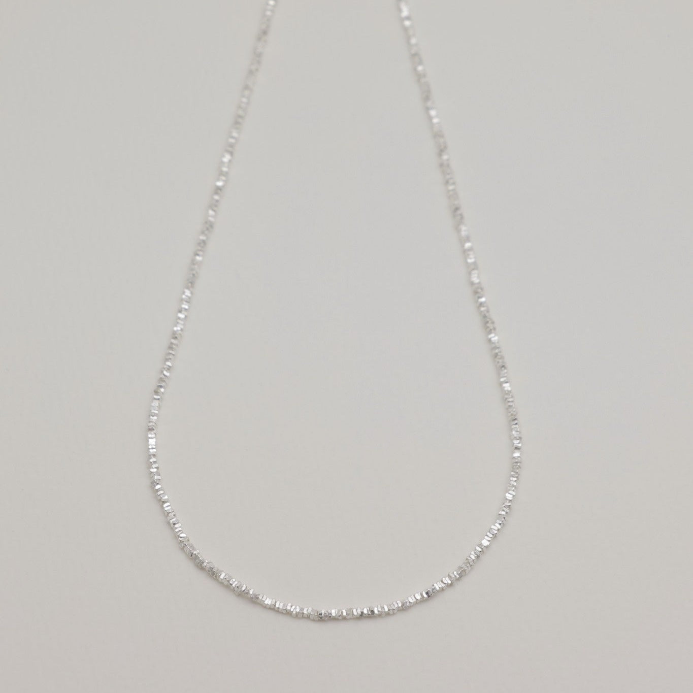 Full view of the Victoire Necklace laid flat showing its elegant length and clasp