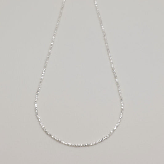 Full view of the Victoire Necklace laid flat showing its elegant length and clasp