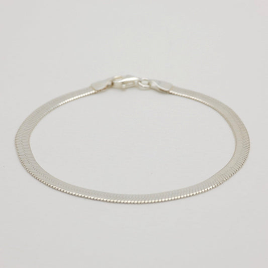 Flat herringbone bracelet in polished sterling silver with lobster clasp.