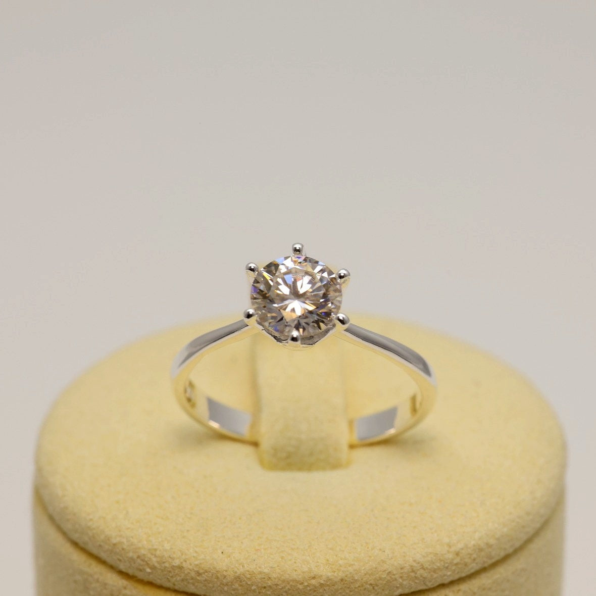 Close-up of silver solitaire ring reflecting natural light on clean surface

