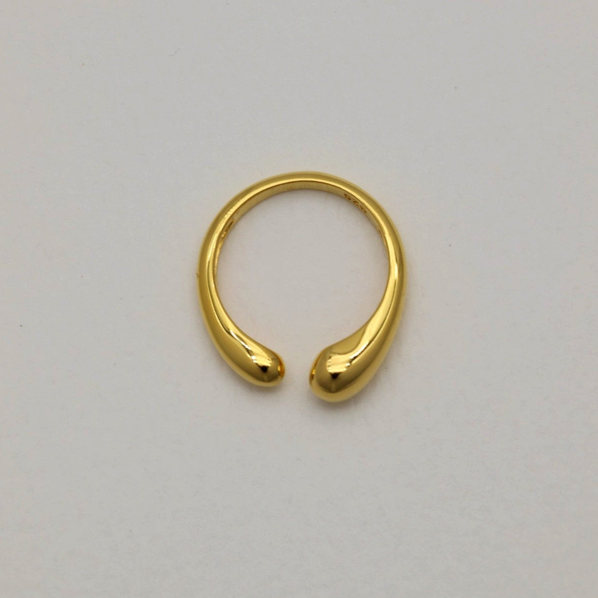 Top-down view of Delphine Curve Ring in gold vermeil showing its sculptural open shape on a light background