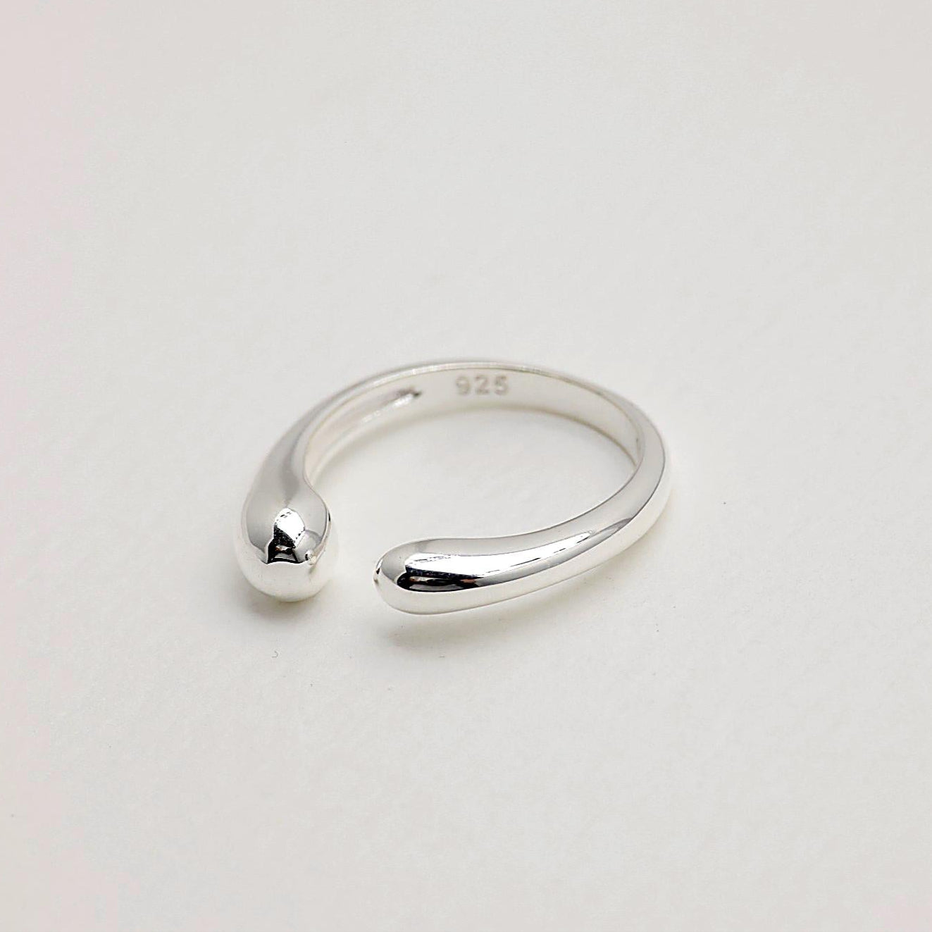 Close-up angled view of the Delphine Curve Ring in polished sterling silver on a white background.