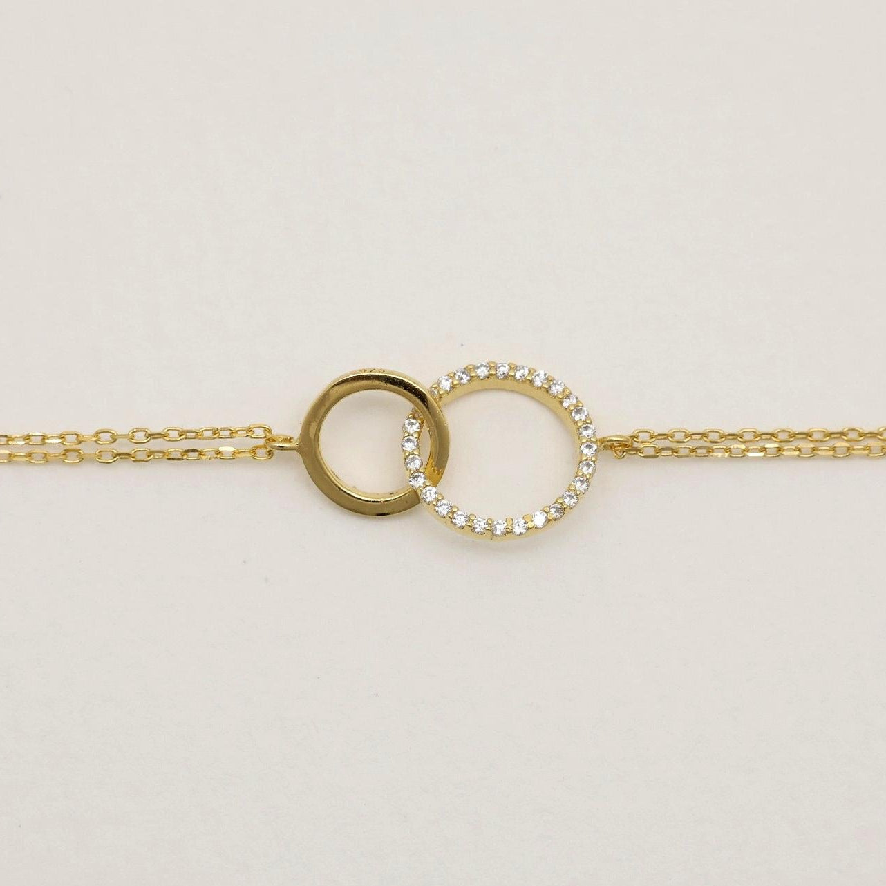 “Delicate double chain bracelet with pavé and polished circle design”

