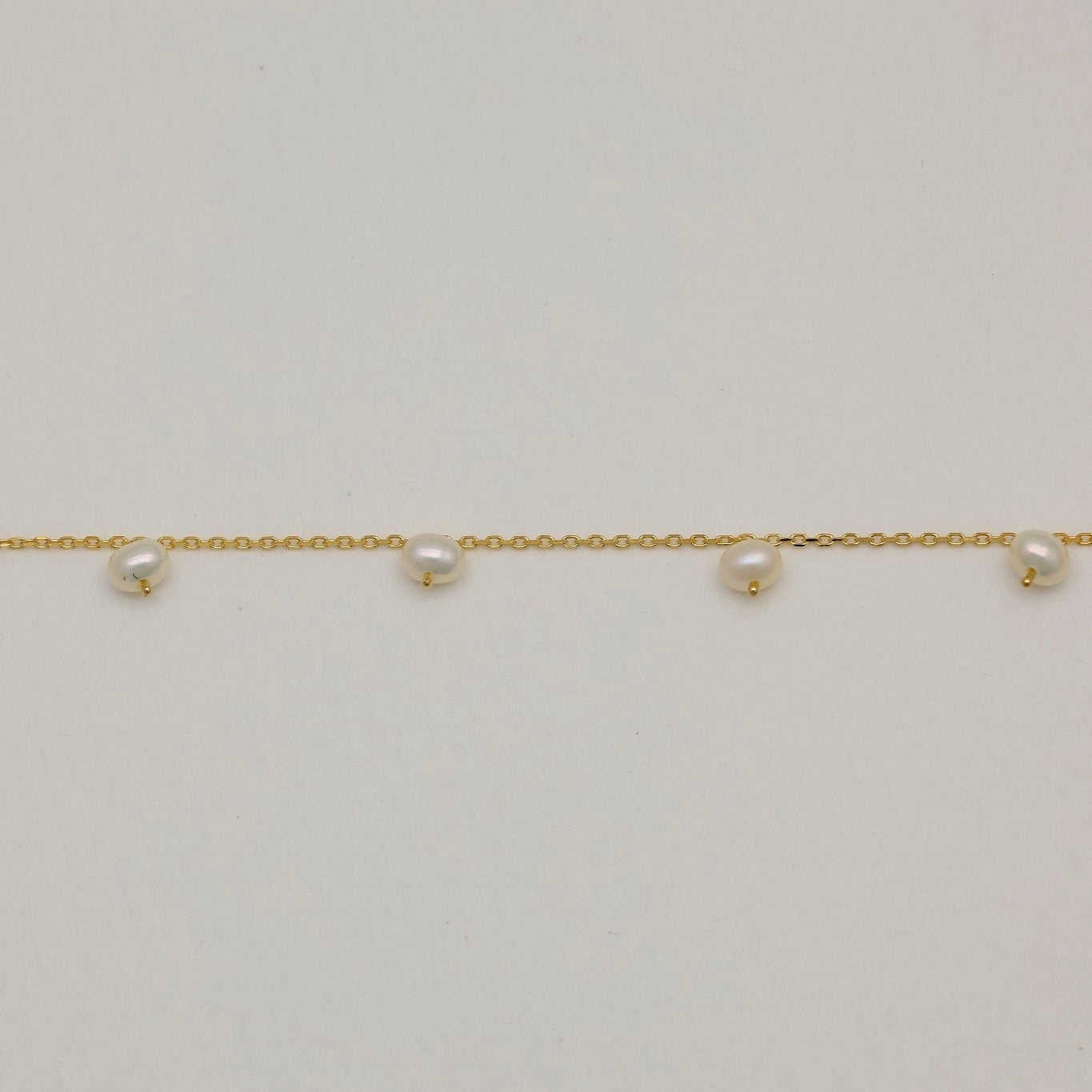 Close-up side angle of Lilou bracelet showing pearl texture and chain

