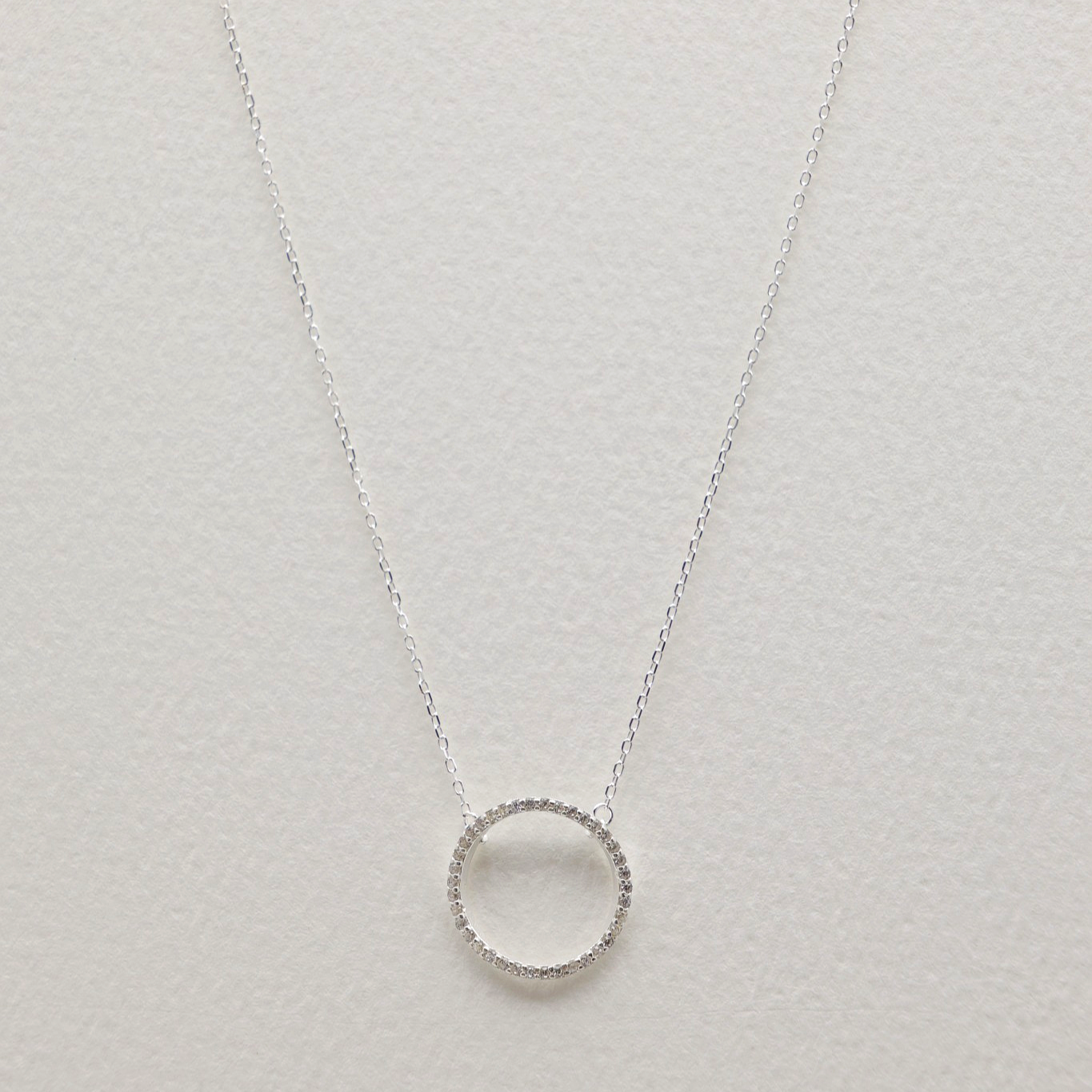 Full overhead shot of the necklace laid flat, showing both the pendant and the clasp with extension chain.