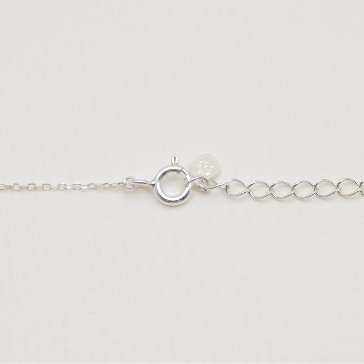 Silver bracelet on a light gray background