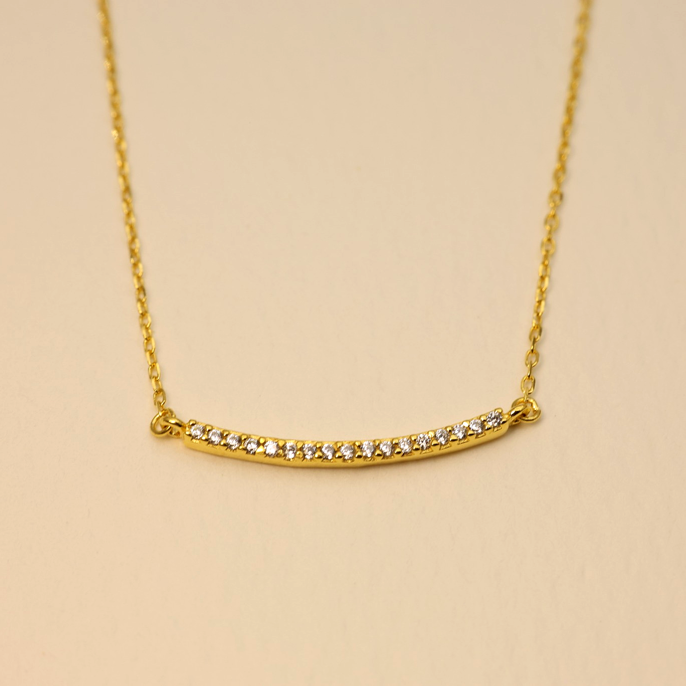 Close-up of curved bar pendant with cubic zirconia on gold vermeil chain – Clémence Necklace