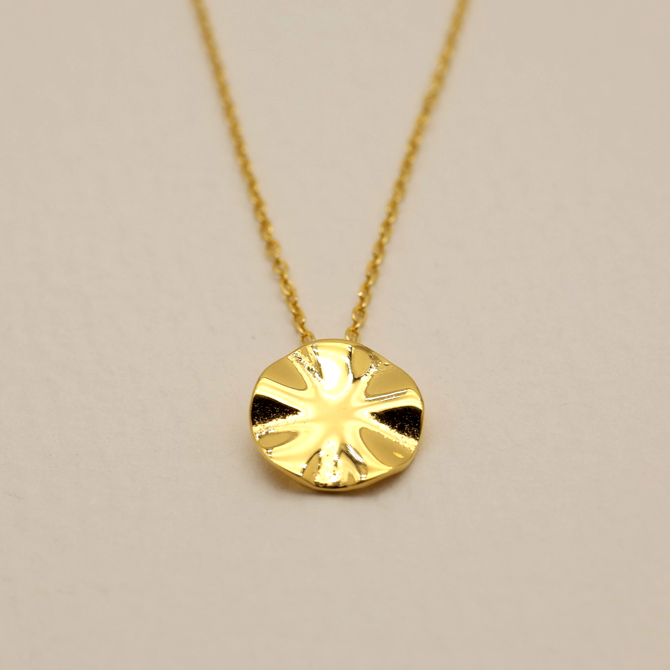 Close-up of the Éline Polished Necklace in gold vermeil with sculptural round pendant
