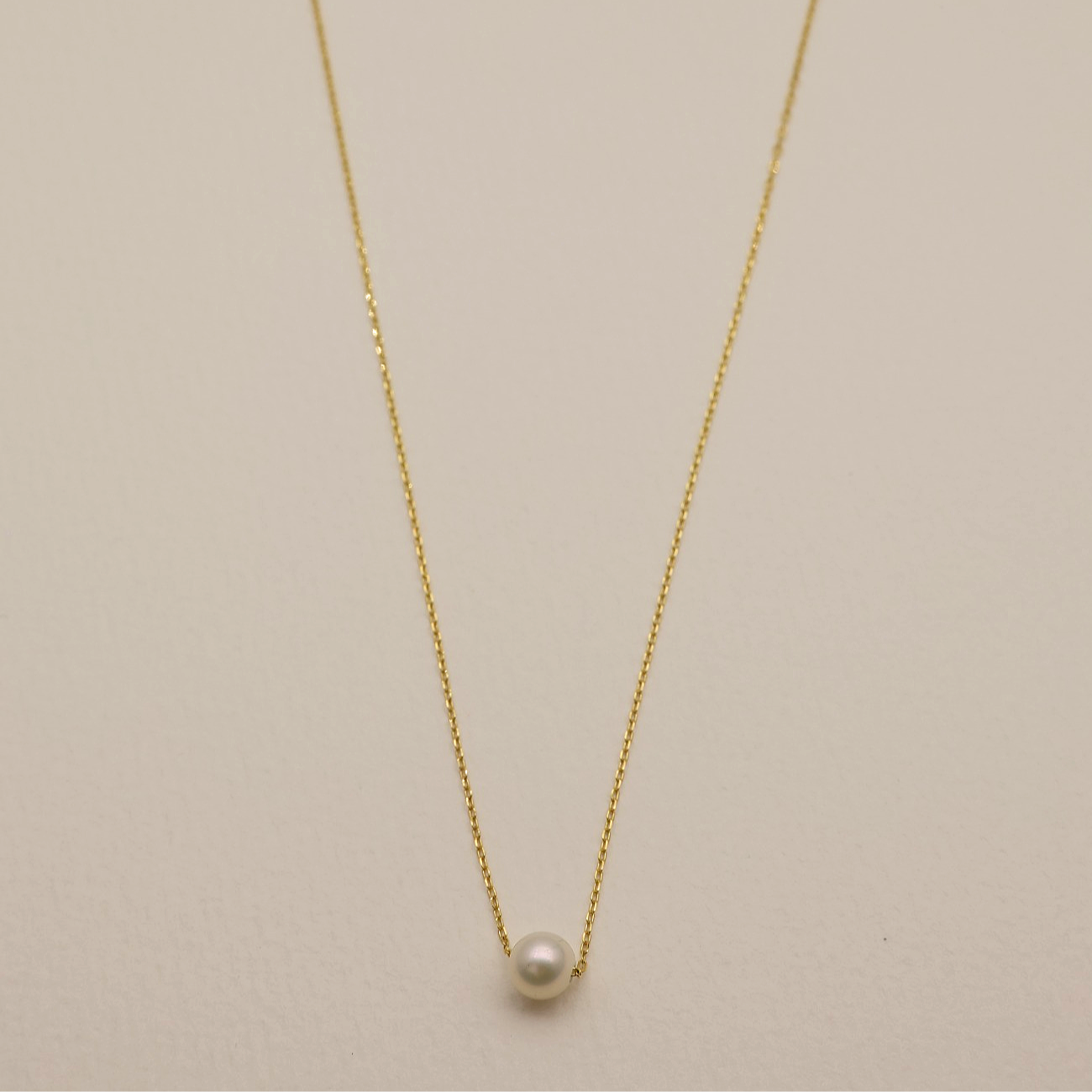 Full-length image of the Élodie Pearl Necklace laid flat