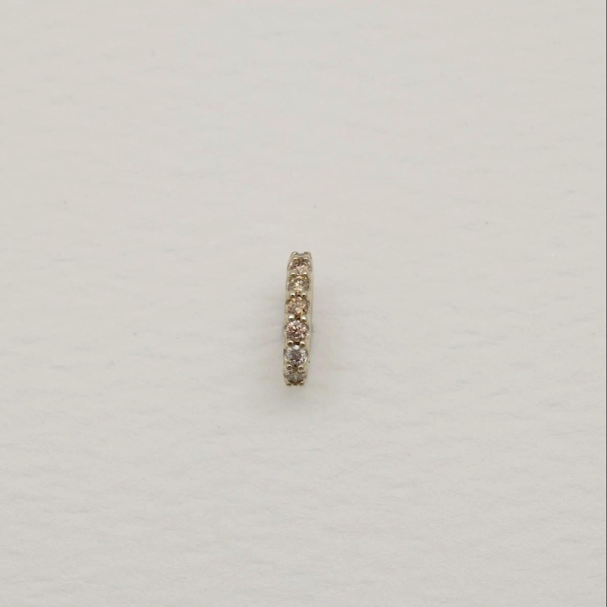 Gold ring with small stones on a light gray background