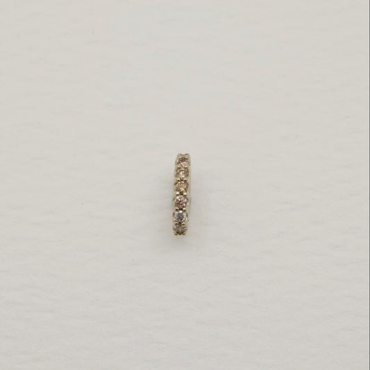 Gold ring with small stones on a light gray background