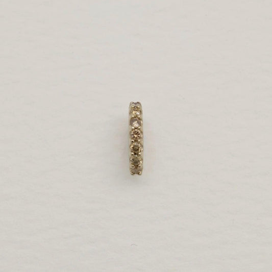 14K gold oval charm with natural pavé diamonds along one edge, photographed on a soft white background.