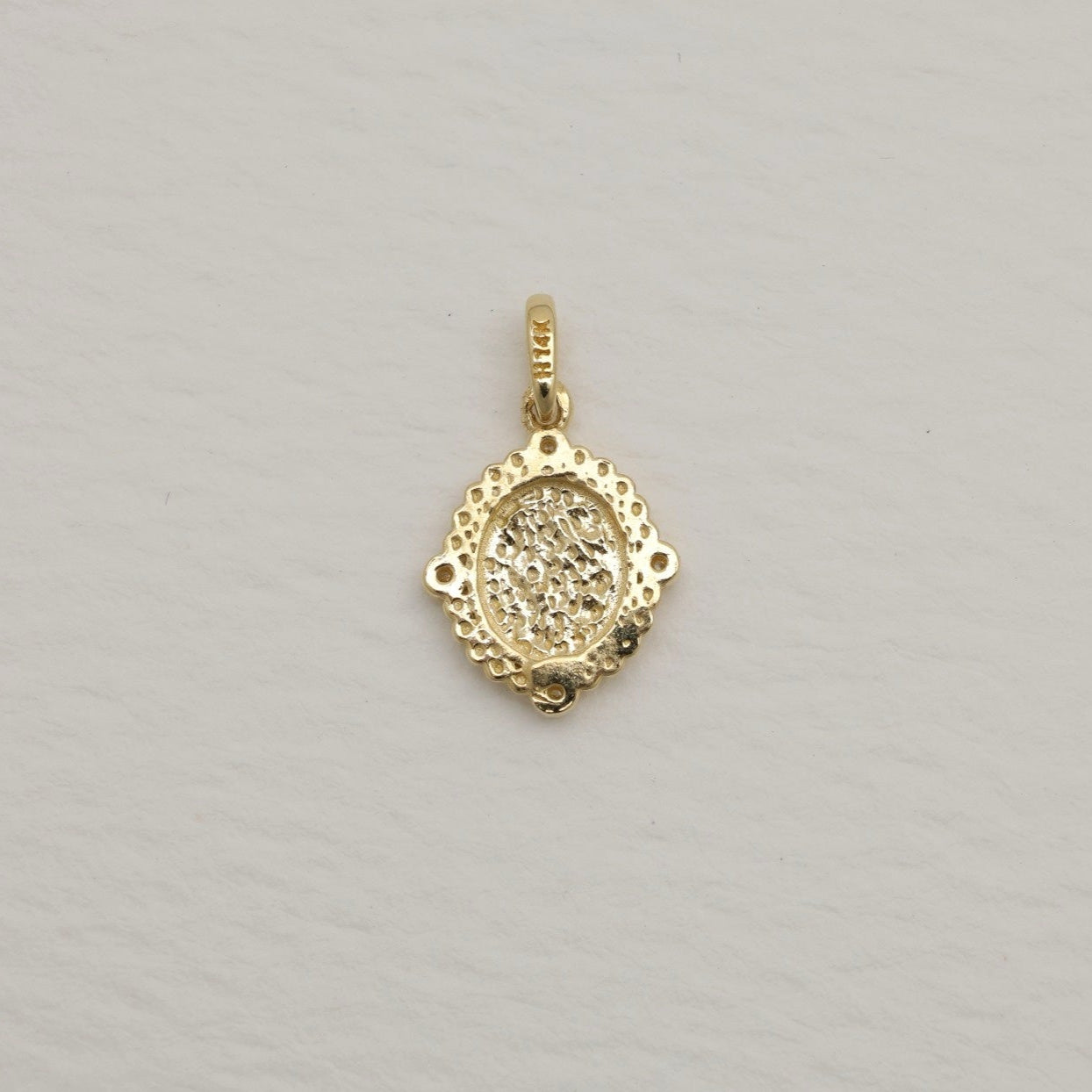 14K gold charm pendant with oval brushed center and four cubic zirconia, surrounded by beaded details.