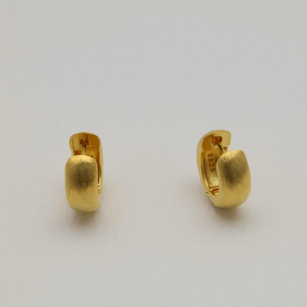 Pair of matte brushed mini gold vermeil hoop earrings on white background.