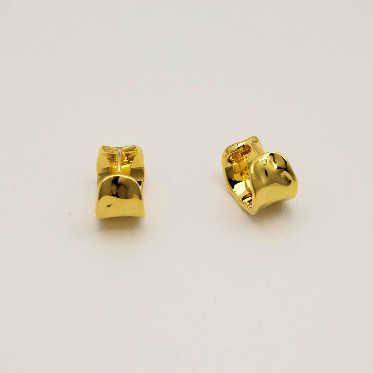 Pair of gold earrings on a light gray background