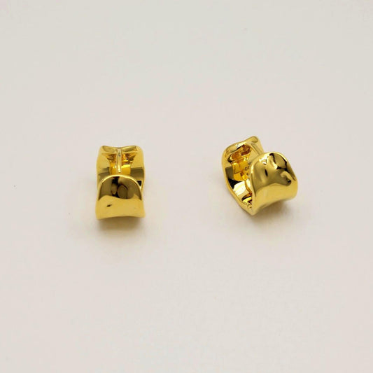 Pair of gold earrings on a light gray background