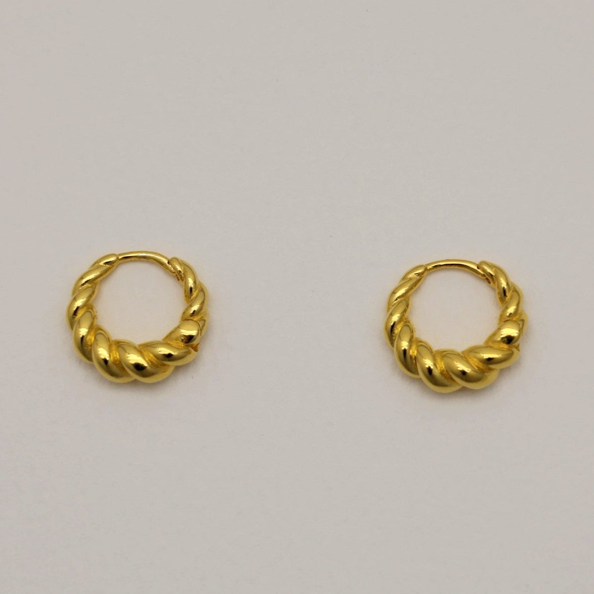 Matte gold vermeil rope twist mini hoop earrings with hinge closure, displayed on neutral background.